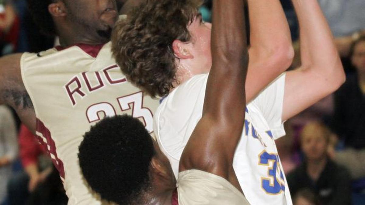 Fort Mill’s Rogan Wells powers through Rock Hill’s Myles Byers, left, and Lance Crayton (1) for a layup Friday.