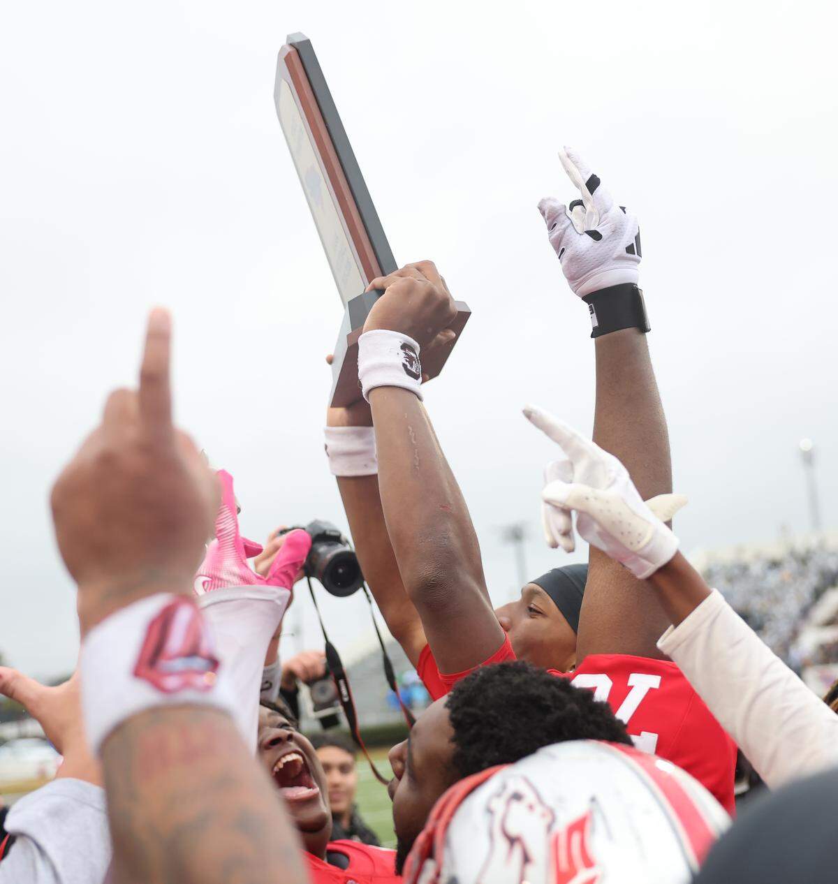 South Pointe's J'zavien Currence holds up the championship trophy Saturday at the SC High School League Class 4A football championship