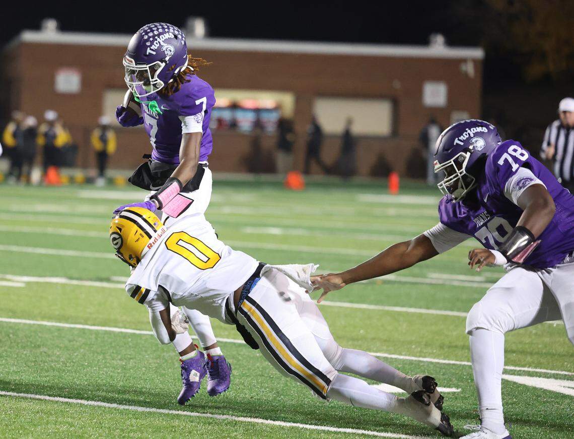 Northwestern’s Tadarrian Knox (7) is met with Greenwood’s Khamari Griffin (0) as Chris Coleman (78) grabs at Griffin Friday in Rock Hill.