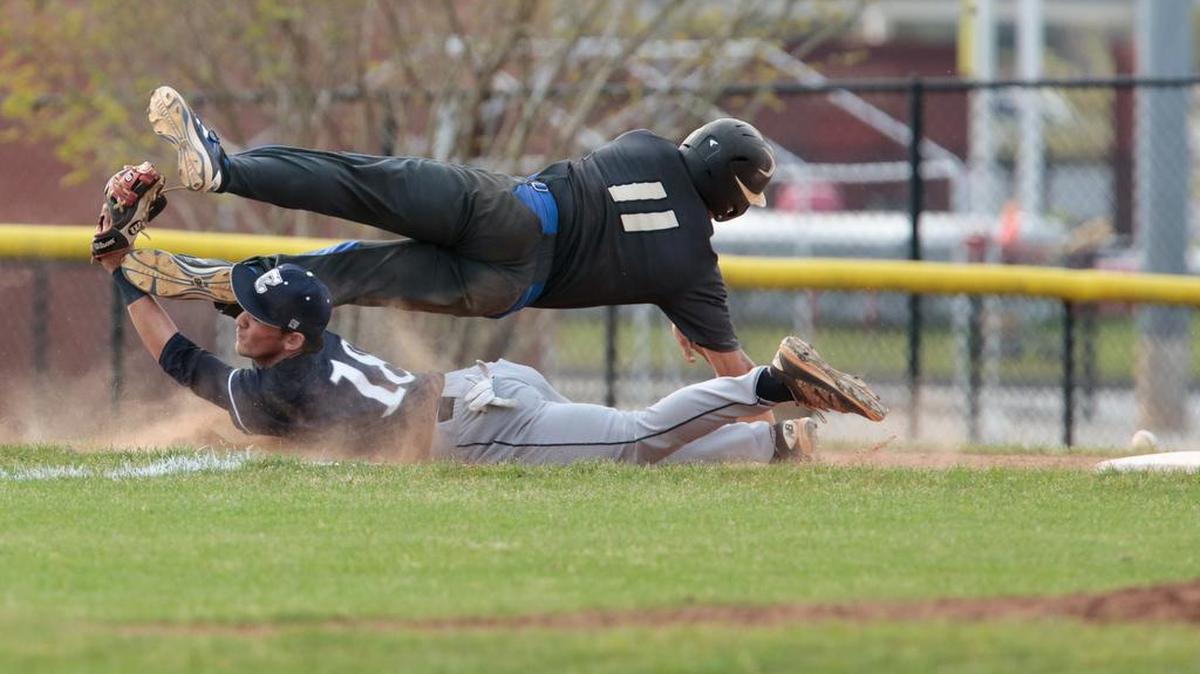 Indian Land's No. 11 Hunter Laney dives over Clover's No. 18 Kevin Riley on his way back to third base as Clover faces off against Indian Land Wednesday evening at South Pointe High School in the 2017 Wheels baseball tournament.