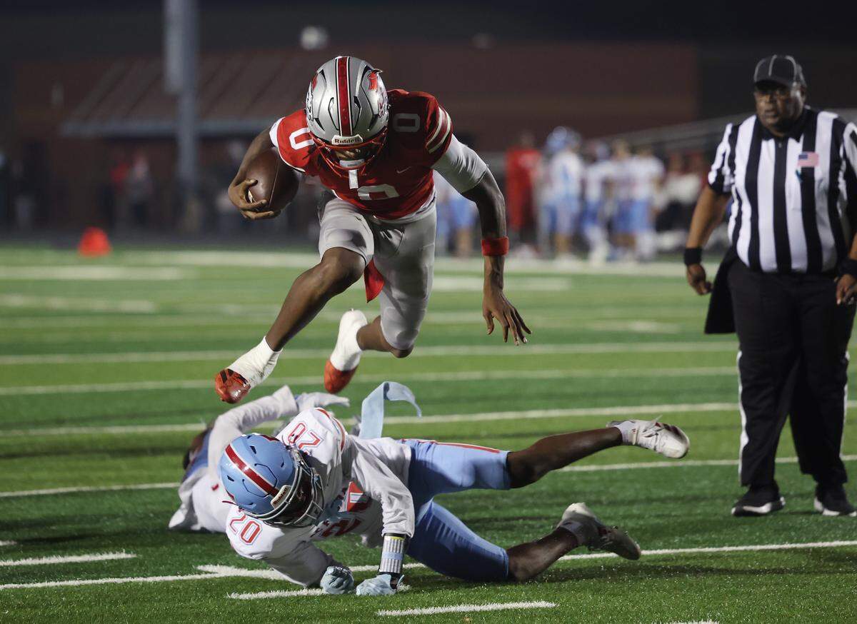 South Pointe's J'zavien Currence leaps over A.C. Flora's Larry Pickett Friday, Nov. 21, 2025 in Rock Hill, S.C.