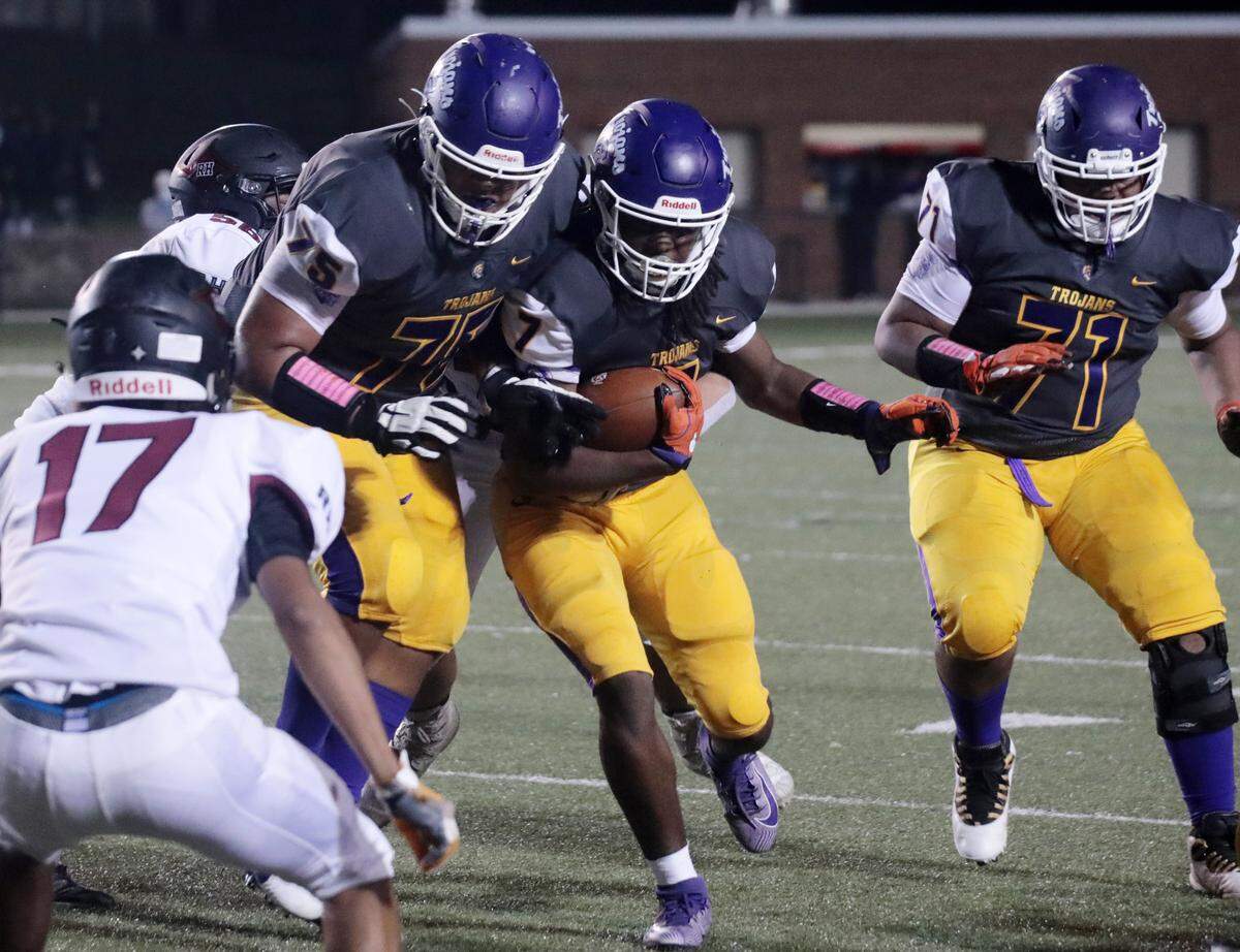 Northwestern’s Jordan Knox (75) and Marcus Macon (71) try to avoid a tackle of Elijah Caldwell (7) by Rock Hill’s Isaac Gilmore (17) Friday as the Trojans and Bearcats meet in Rock Hill.