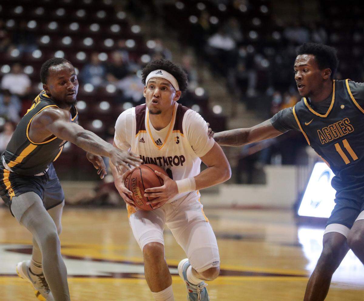 Winthrop’s Drew Buggs looks for an opening against NC A&T’s David Beatty, left, and Tyler Maye.