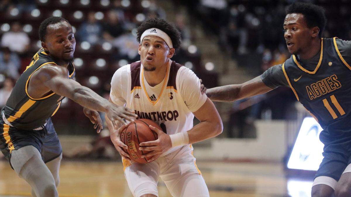 Winthrop’s Drew Buggs looks for an opening against NC A&T’s David Beatty, left, and Tyler Maye.