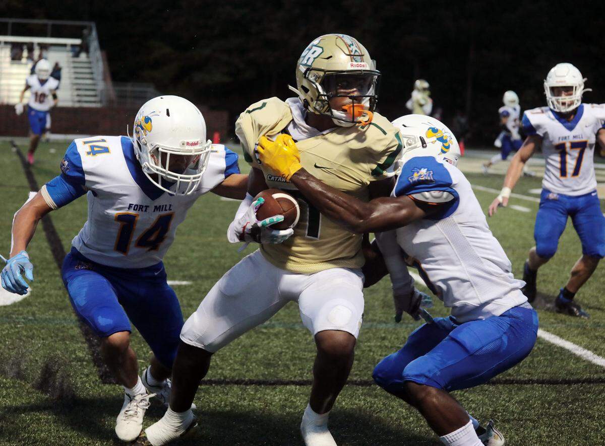 Catawba Ridge’s Jacobie Henderson, center, is tackled by Fort Mill’s T.J. Van Stocken (14) and J.J. Ogwal Friday as the Copperheads and Yellow Jackets compete at Catawba Ridge High School.