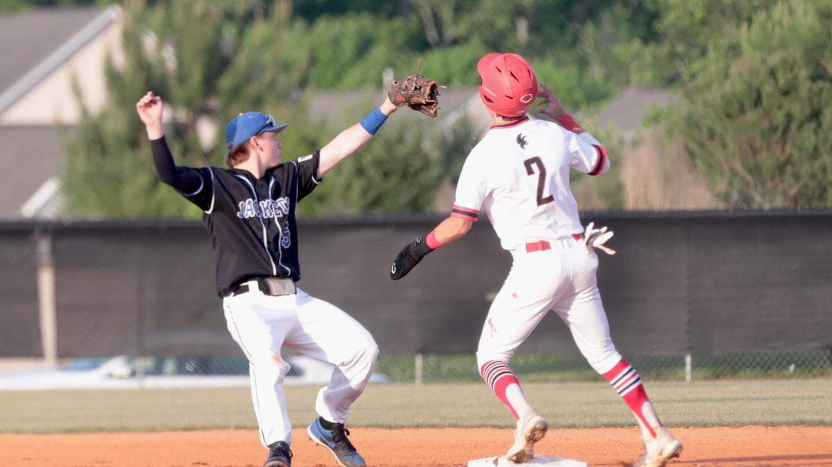 Fort Mill’s Connor Rasmussen, left, misses the ball as Nation Ford’s Kenan Bowman heads to second base.