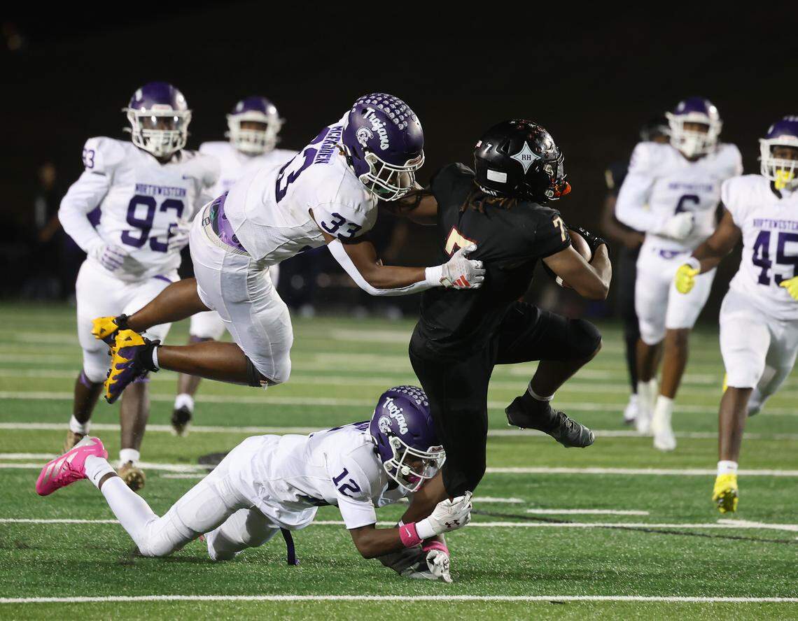 Rock Hill's Nigel Lightner (7) carries the ball as Northwestern's Kamerin McFadden (33) and Jaylon Richardson (12 try to stop him Friday, Oct. 17, 225 in Rock Hill, S.C.