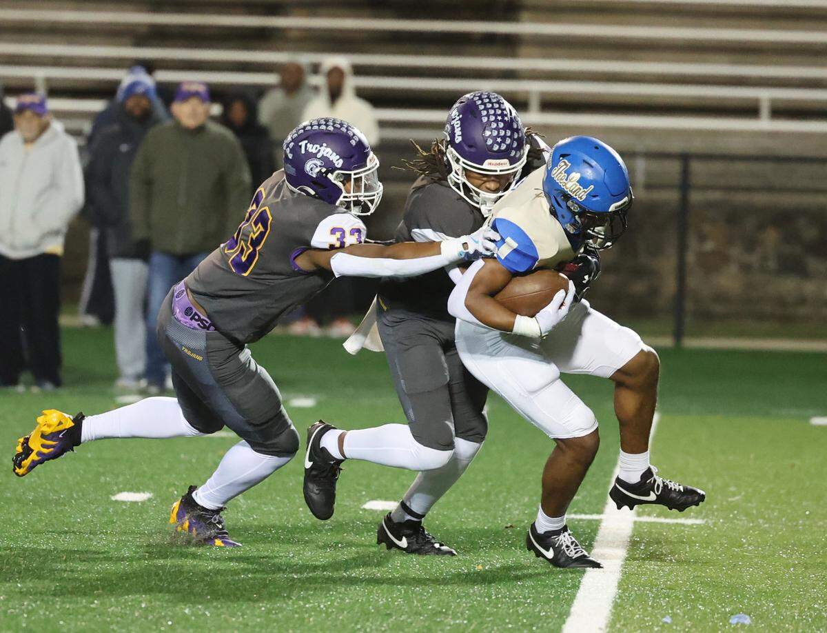 Northwestern’s Kamerin Mcfadden (33) and Tamarion Watkins bring down Indian Land’s Omarion Davis Friday, Nov. 22, 2024 in Rock Hill, S.C.