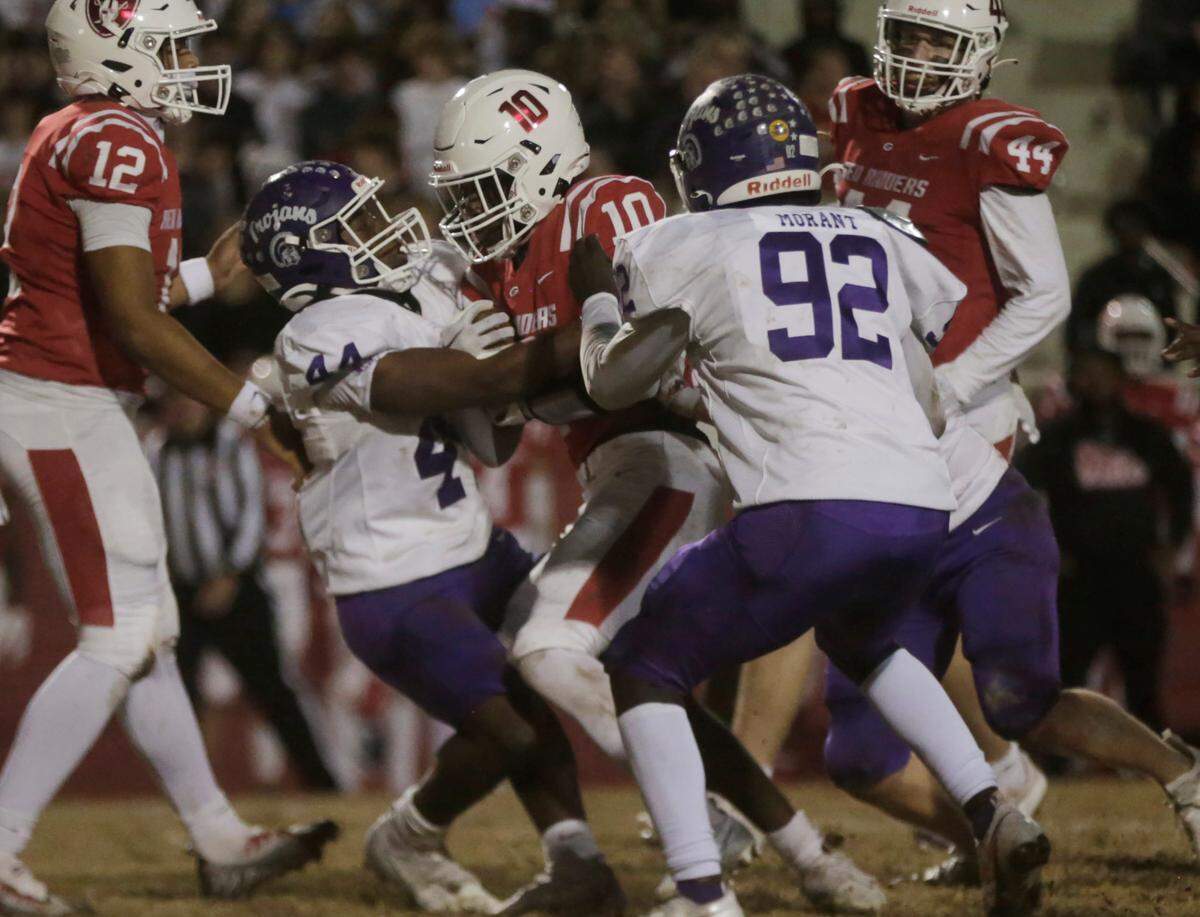 Northwestern’s Will Massey (44) and Khamari Morant (92) pull Greenville’s Ray White (10) down Friday at the Class 4A Upperstate Championship game in Greenville.