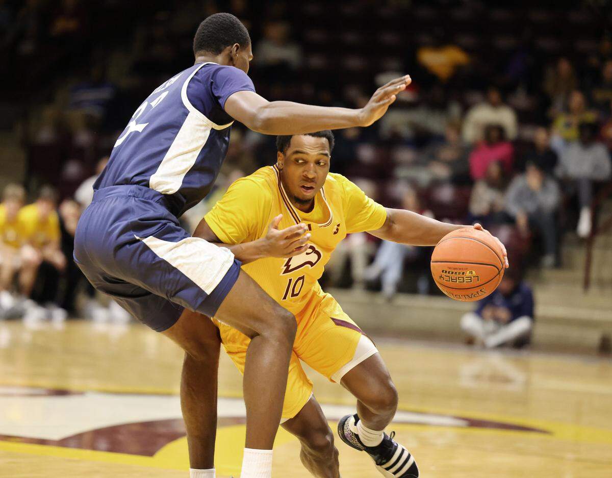 Winthrop’s Nick Johnson tries to pass Queens’ Malcolm Wilson