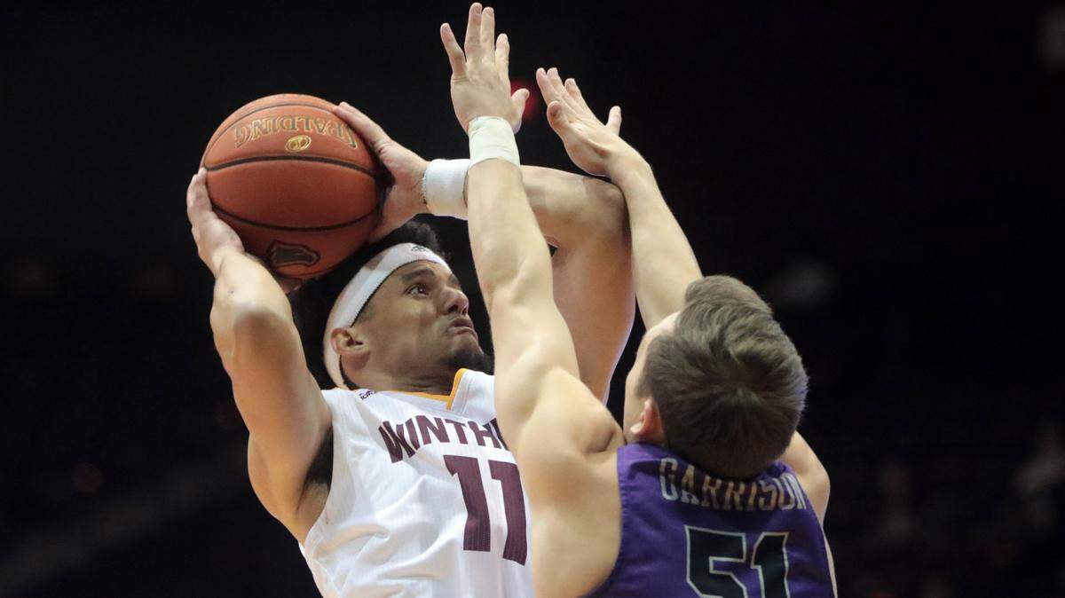 Winthrop’s Drew Buggs puts up the shot against Furman’s Conley Garrison.