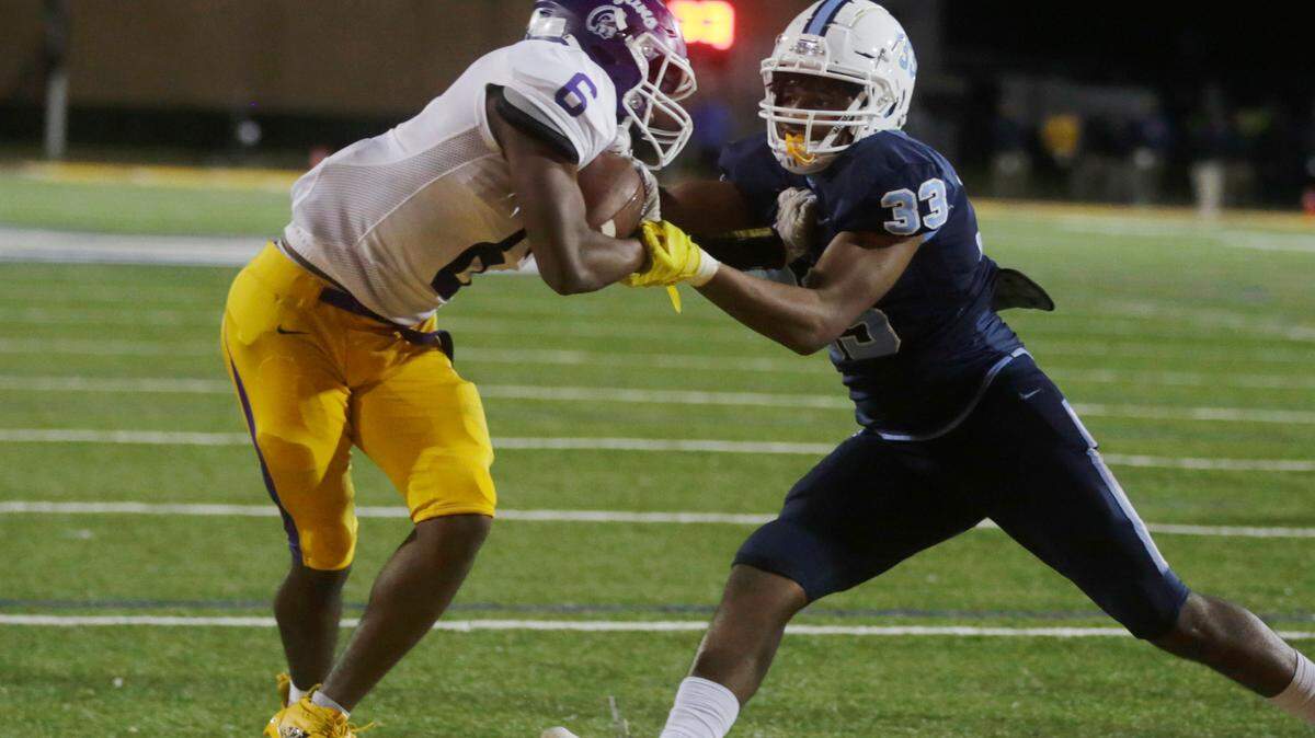 Northwestern’s Juan Fargas fights off South Florence’s Terrance Moorer while scoring a touchdown Friday in Columbia during the Class 4A state championship game.