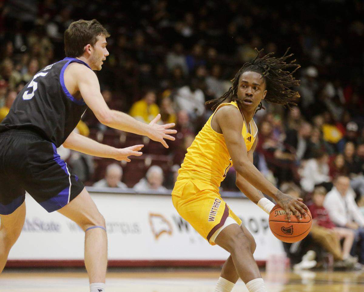 Winthrop’s Sin’Cere McMahon looks for an opening against Asheville’s Fletcher Abee