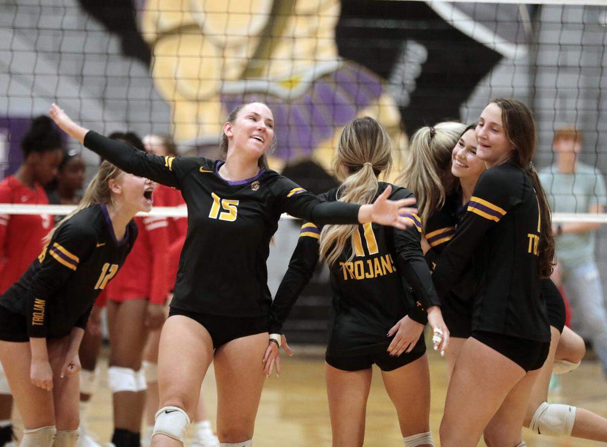 Girls on the Northwestern High School volleyball team cheer after a set Wednesday.