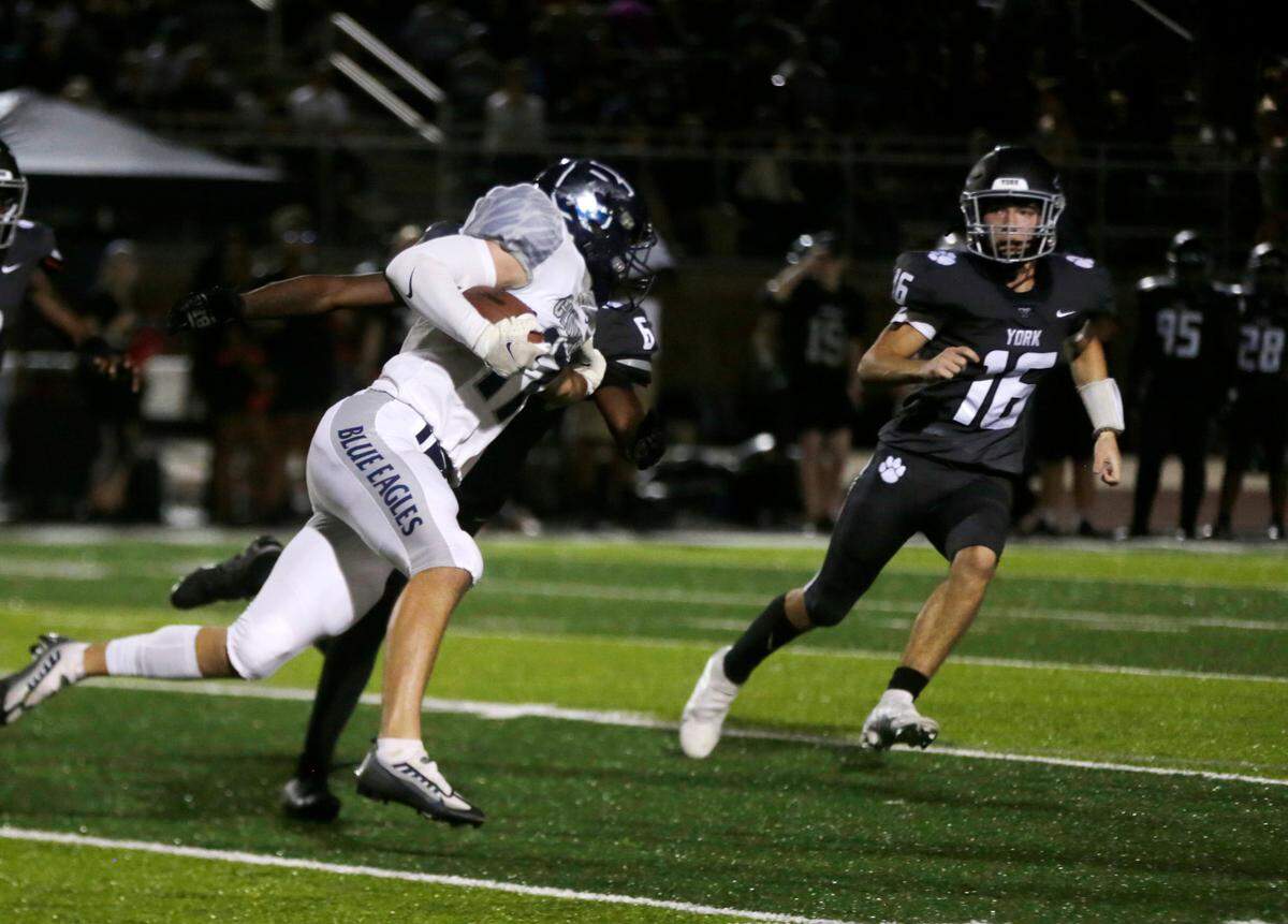 Clover’s Cooper Zohner runs in the direction of York’s Triston Barnette (16) Friday, Sept. 9, 2022 at the rivalry game in York.