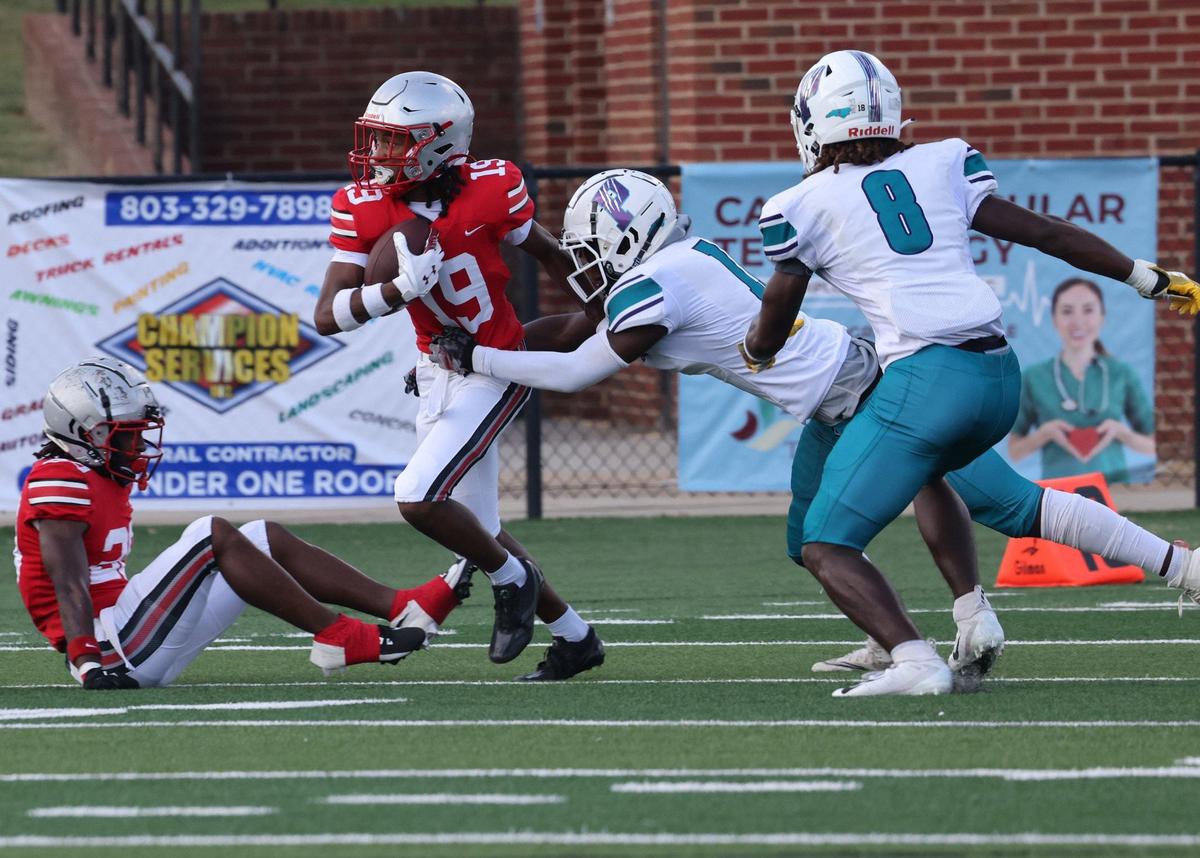 South Pointe’s Kadin Vassel (19) carries the ball as the Palisades’ Caleb Taylor pulls him down Friday at the WRHI Football City USA scrimmage in Rock Hill.
