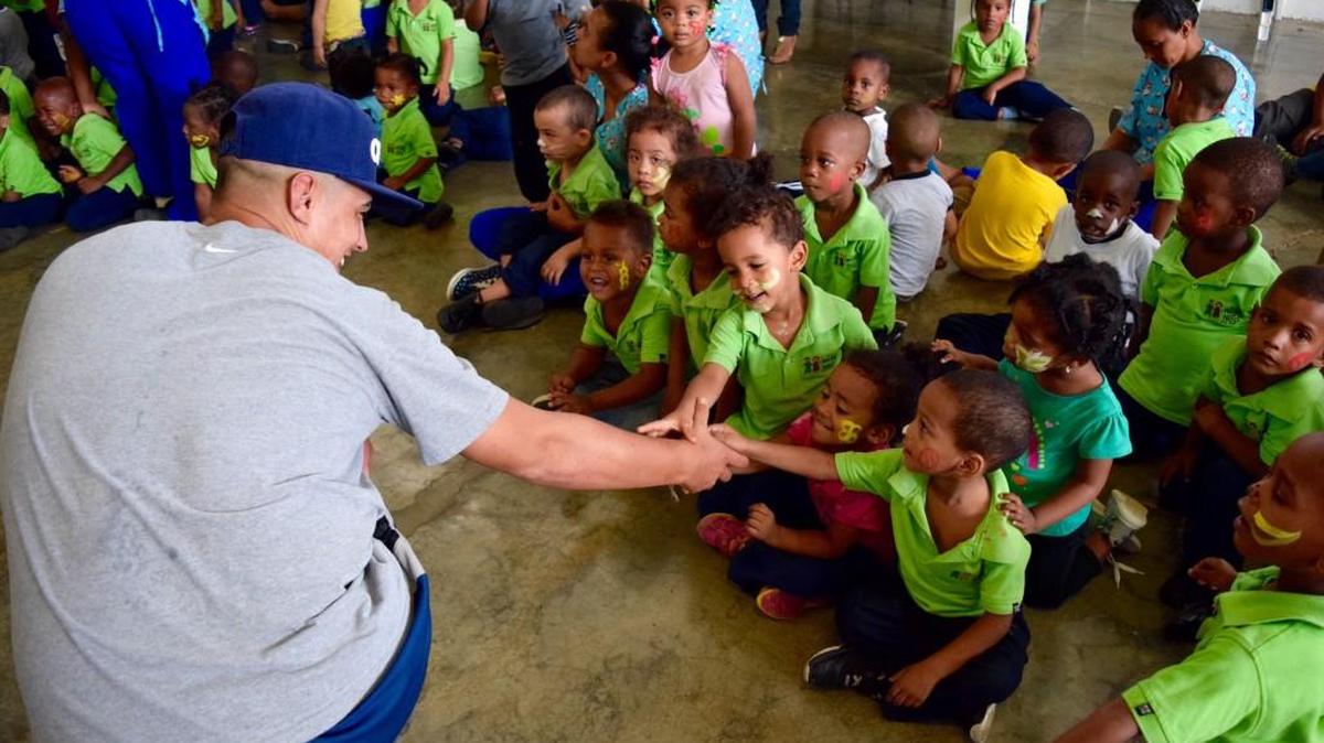 A Piedmont Pride player interacts with children in the Dominican Republic.