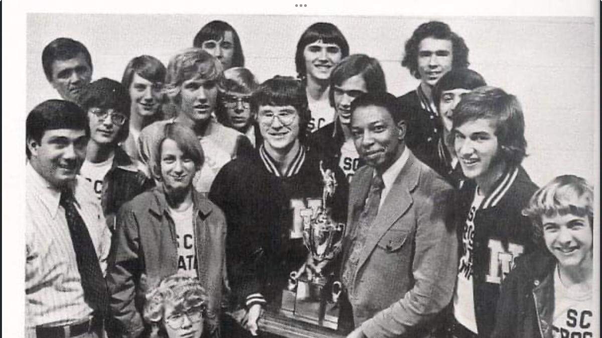 Northwestern’s 1973 boys cross country team poses for a photo with the state championship trophy. Holding the trophy is Northwestern principal Sam Foster (right, dark suit) and John Schwartz (left, dark letter jacket). In the photo also is athletic director Doug Echols (far left; white shirt, black tie), Bob Jenkins (back row, far left), Robert Beaty (back row, far right) and Ronnie Covington (front row, second from right; dark letter jacket).
