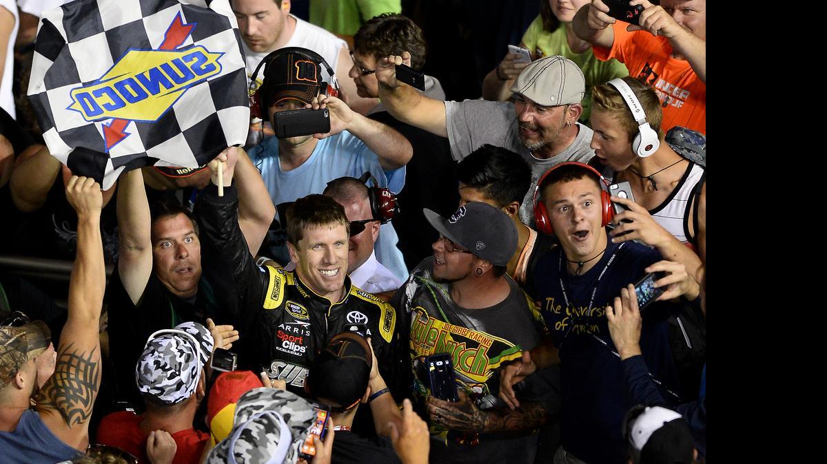 
NASCAR Sprint Cup Series driver Carl Edwards celebrates his victory in the Coca-Cola 600 with fans in the grandstand at Charlotte Motor Speedway on Sunday, May 24, 2015.
