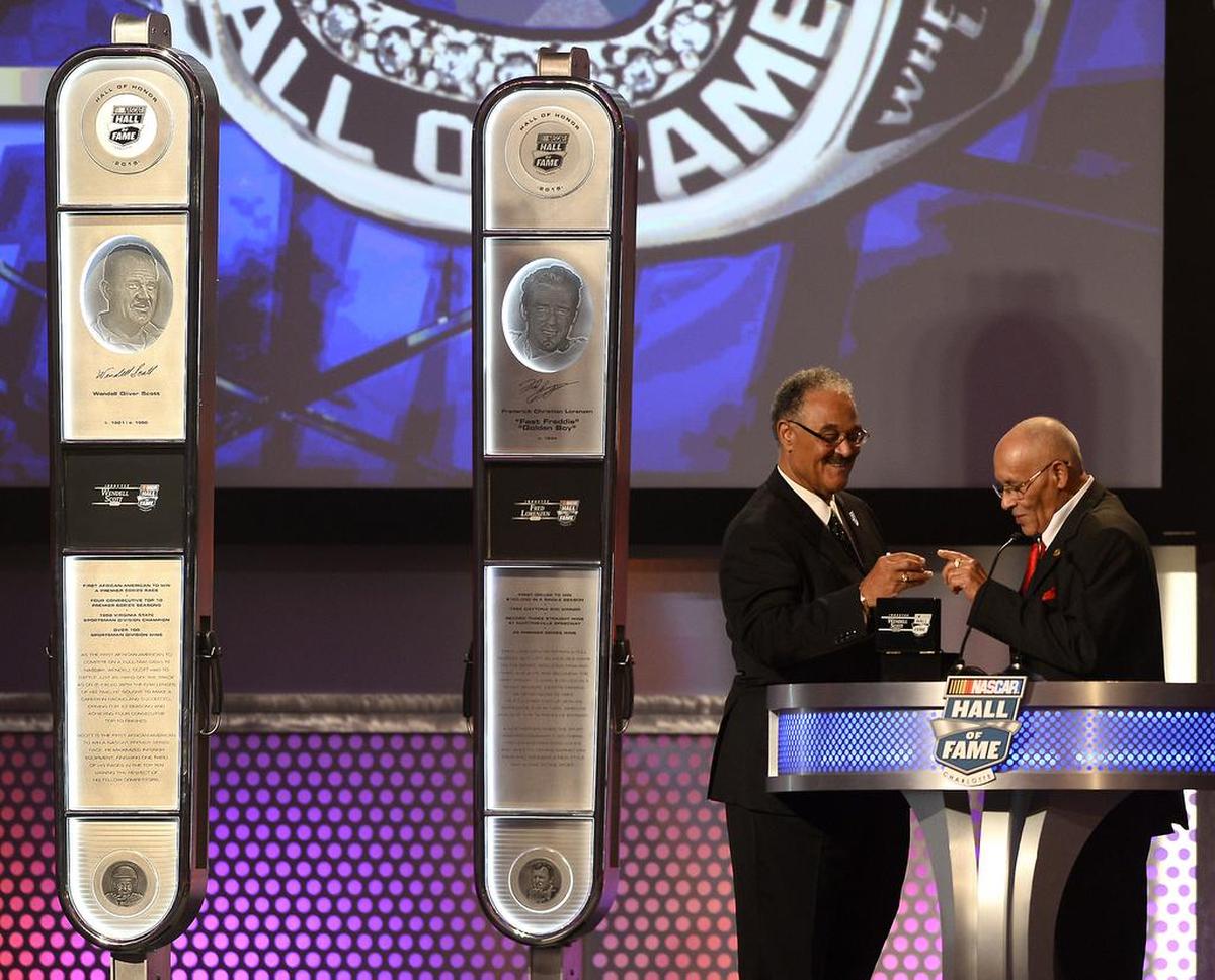 Former NASCAR driver Wendell Scott’s son Franklin Scott hands his father’s Hall of Fame ring to his brother, Wendell Scott Jr., during the NASCAR Hall of Fame Class of 2015 Induction Ceremony on Jan. 30, 2015. Mary Scott was unable to attend the ceremony.