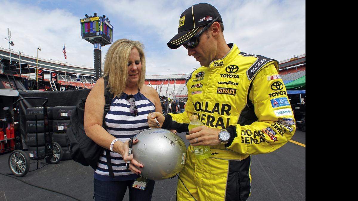 
Matt Kenseth signs an autograph for Barb Komjati on Friday before qualifying for Sunday’s Sprint Cup race at Bristol Motor Speedway. Kenseth took the pole, and two more Joe Gibbs Racing drivers (Carl Edwards, Denny Hamlin) earned spots in the top five.
