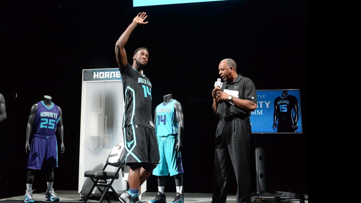 
 Charlotte Hornets forward Michael Kidd-Gilchrist on left, shows off the new “Buzz City” alternate jersey with former Hornets star Dell Curry, right, before the start of Thursday's NBA draft at Time Warner Cable Arena. 
