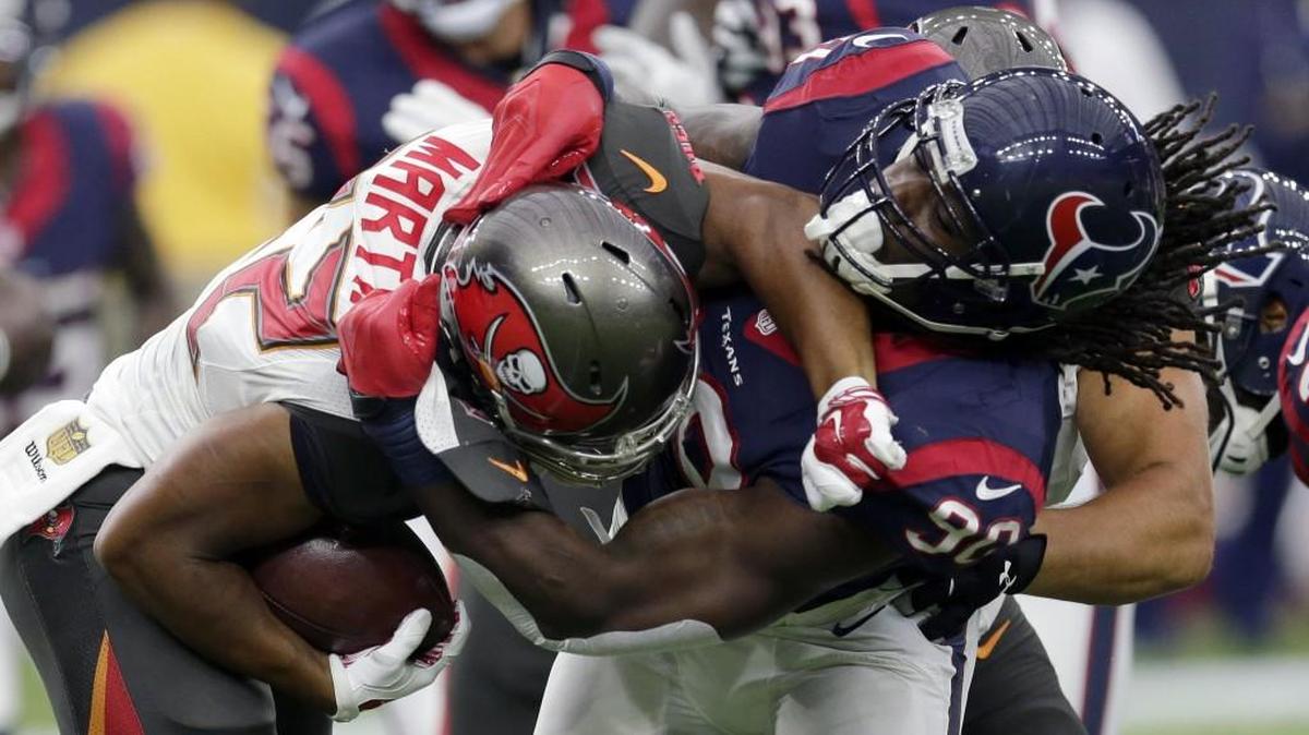 
Tampa Bay Buccaneers' Doug Martin (22) is wrapped up by Houston Texans' Jadeveon Clowney (90) during the first half of an NFL football game Sunday, Sept. 27, 2015, in Houston.
