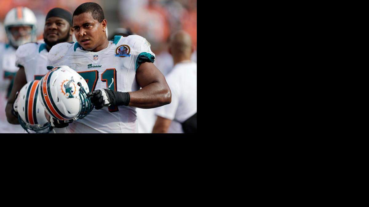
In this Dec. 16, 2012 file photo, Miami Dolphins tackle Jonathan Martin (71) watches from the sidelines during the second half of an NFL football game against the Jacksonville Jaguars, in Miami. Martin was subjected to "a pattern of harassment" that included racist slurs and vicious sexual taunts about his mother and sister by three teammates, according to a report ordered by the NFL. 
