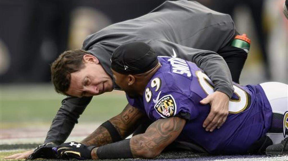 A trainer tends to Baltimore Ravens wide receiver Steve Smith (89) after an injury during the second half of an NFL football game against the San Diego Chargers in Baltimore, Sunday, Nov. 1, 2015. The Ravens defeated the Chargers 29-26.