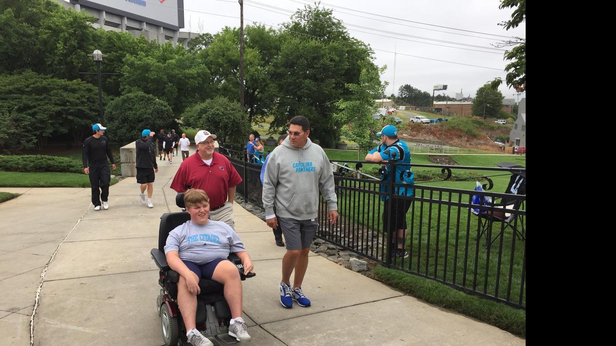 
Panthers coach Ron Rivera, right, invites Seth Myers, in town for a doctor’s appointment, and his father, Douglas, to the team’s practice Thursday. 
