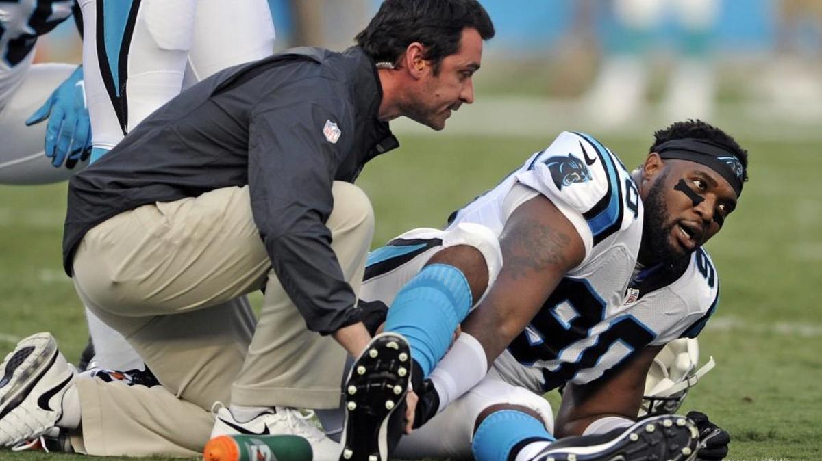 
Carolina Panthers defensive end Frank Alexander grabs his leg as a trainer checks on him after being injured during the first half of an NFL preseason football game against the Miami Dolphins in Charlotte.  Alexander tore his Achilles Saturday against Miami and is out for the season.
