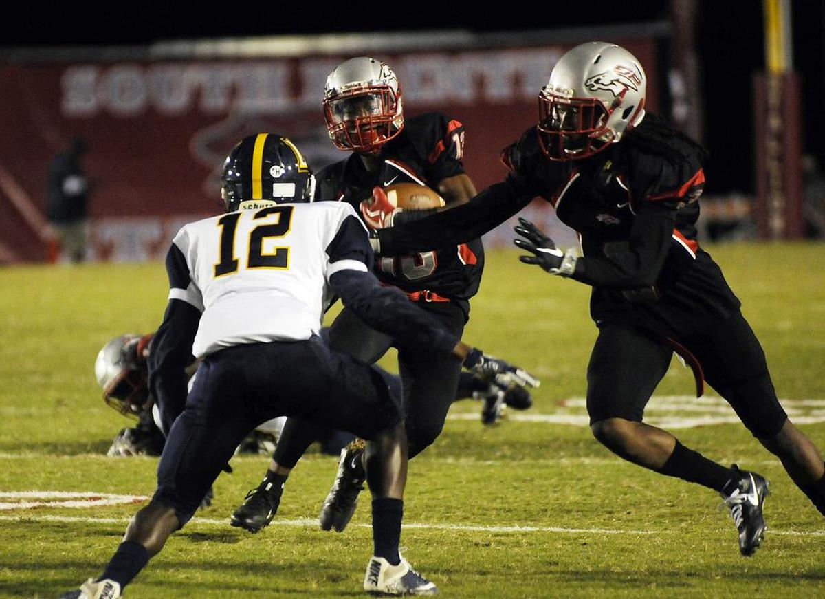South Pointe’s Isaac Ross (13) carries the ball as Steven Gilmore, left, holds back Lancaster’s Nehemia Bailey.