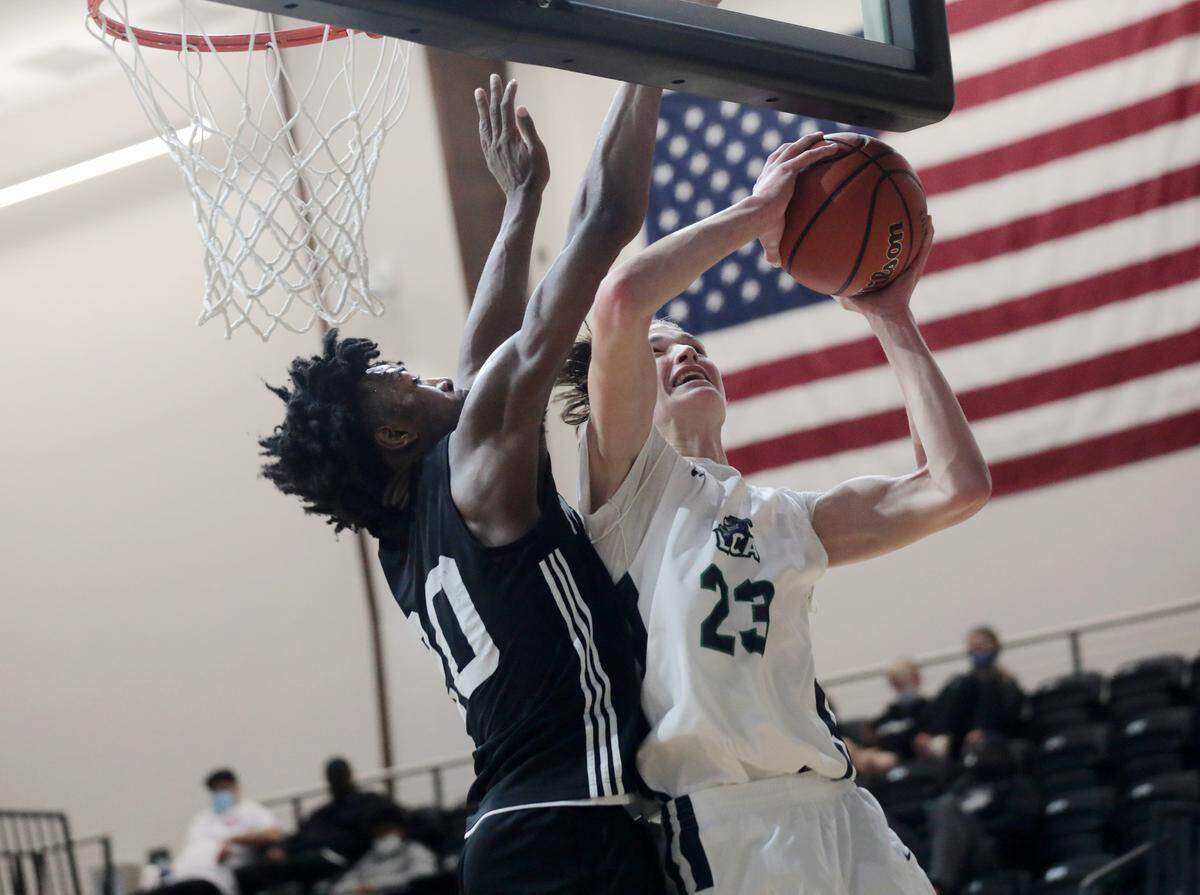 Legion Collegiate’s Marcus Kell puts up the shot beside Moravian’s Ray Bellamy Thursday as the teams compete in the Battle at the Rock High School Basketball Showcase at the Rock Hill Sports and Event Center.