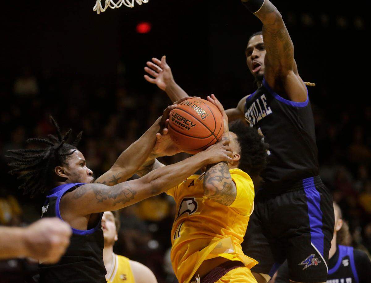 Winthrop’s Kasen Harrison, middle, fights for control of the ball with Asheville’s Caleb Burgess, left, and Jamon Battle.