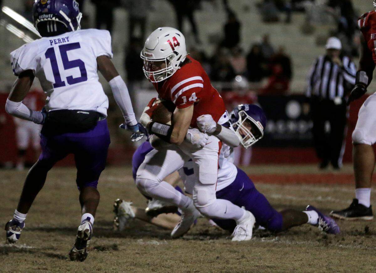 Greenville’s Caleb Krall is brought down by Northwestern’s Melveion Robinson Friday at the Class 4A Upperstate Championship game in Greenville, S.C.