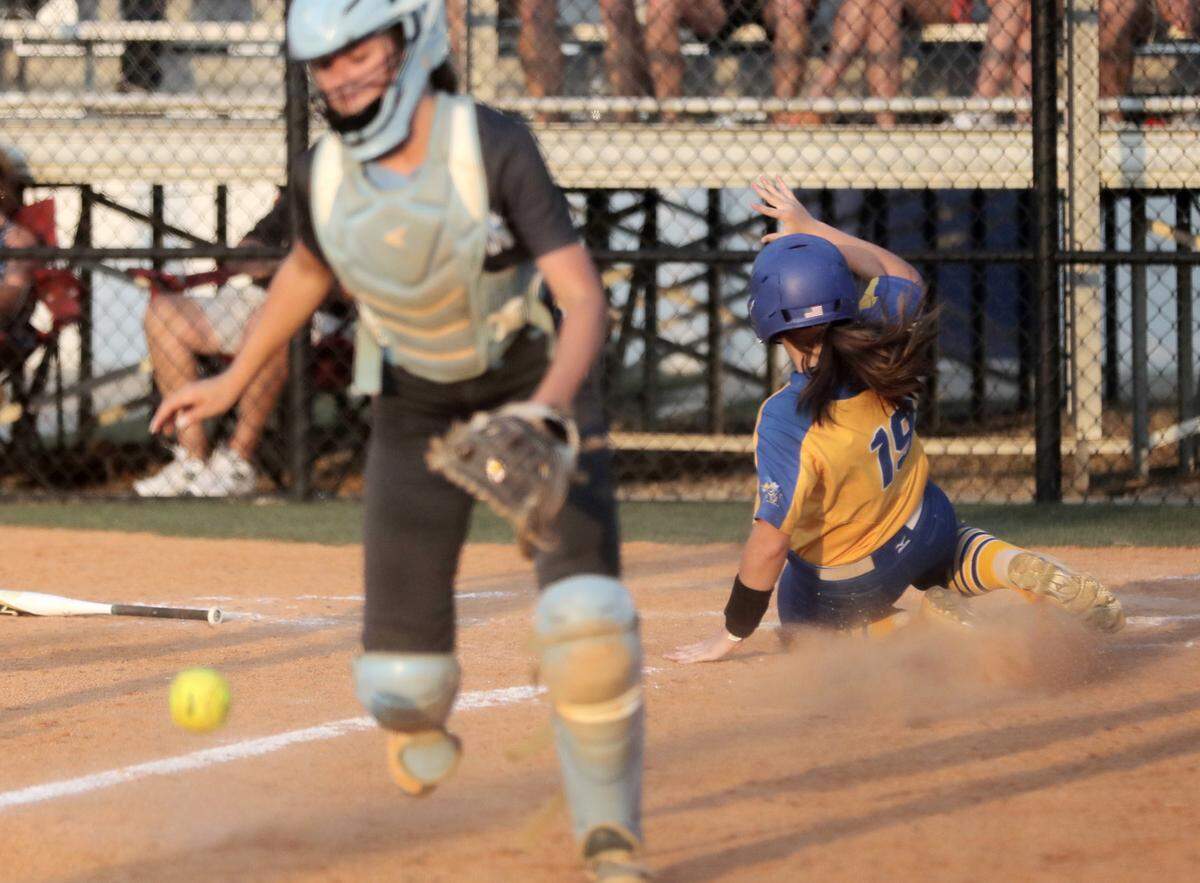 Fort Mill’s Gracyn Hagler slides into home plate as Dorman’s Emma Bright scrambles for the ball.