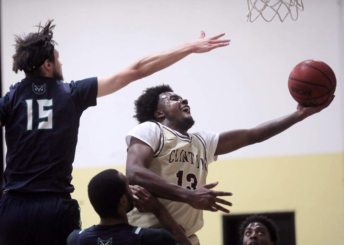Clinton’s Cameron Shannon shoots the ball against Warren Wilson’s Jerry Daye (15).