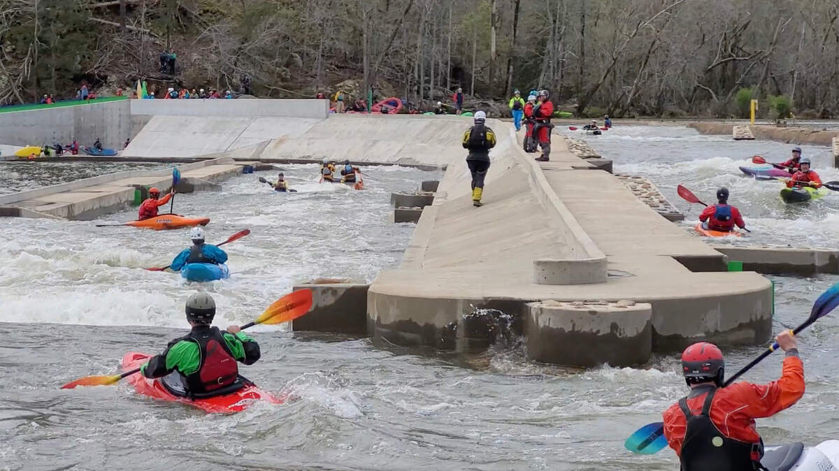 More than a dozen kayakers paddle the “paperclip” at the long bypass on the Catawba River in Great Falls, S.C.