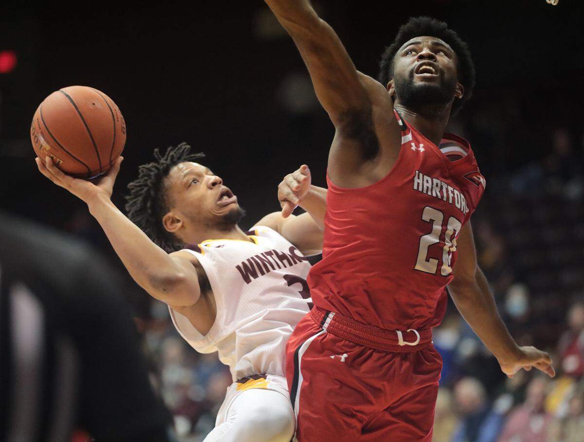 Winthrop’s Micheal Anumba shoots behind Hartford’s Austin Williams.