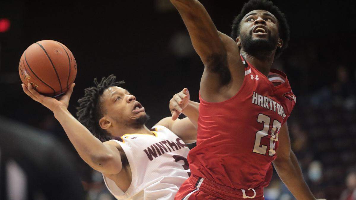 Winthrop’s Micheal Anumba shoots behind Hartford’s Austin Williams.