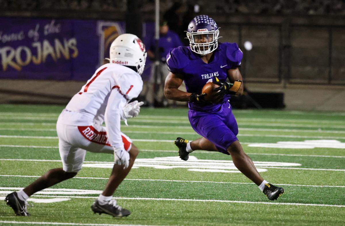 Northwestern’s Turbo Richard carries the ball against Greenville’s Christian Henderson.