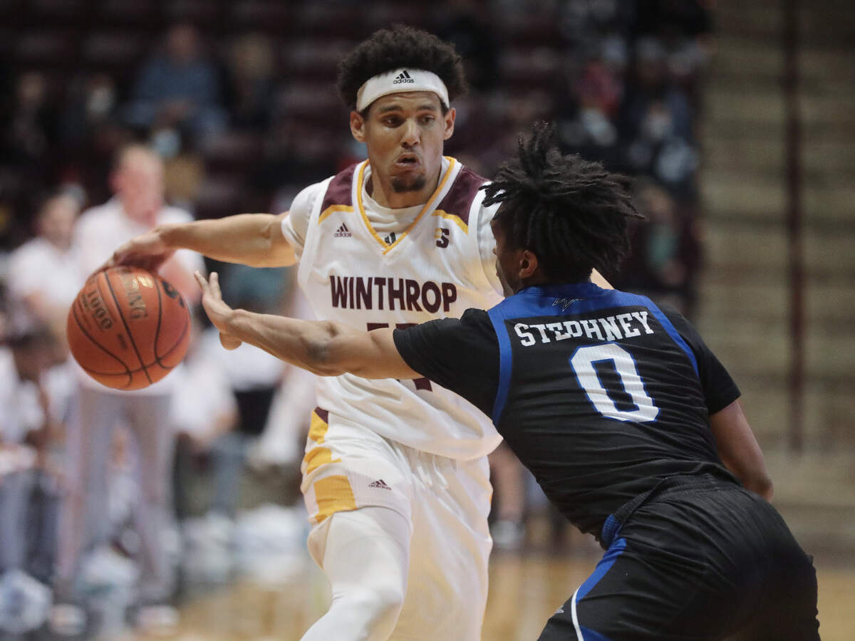 Winthrop’s Drew Buggs heads down the court against UNC Asheville’s Trent Stepney Thursday as the Eagles take on the Bulldogs in Rock Hill.