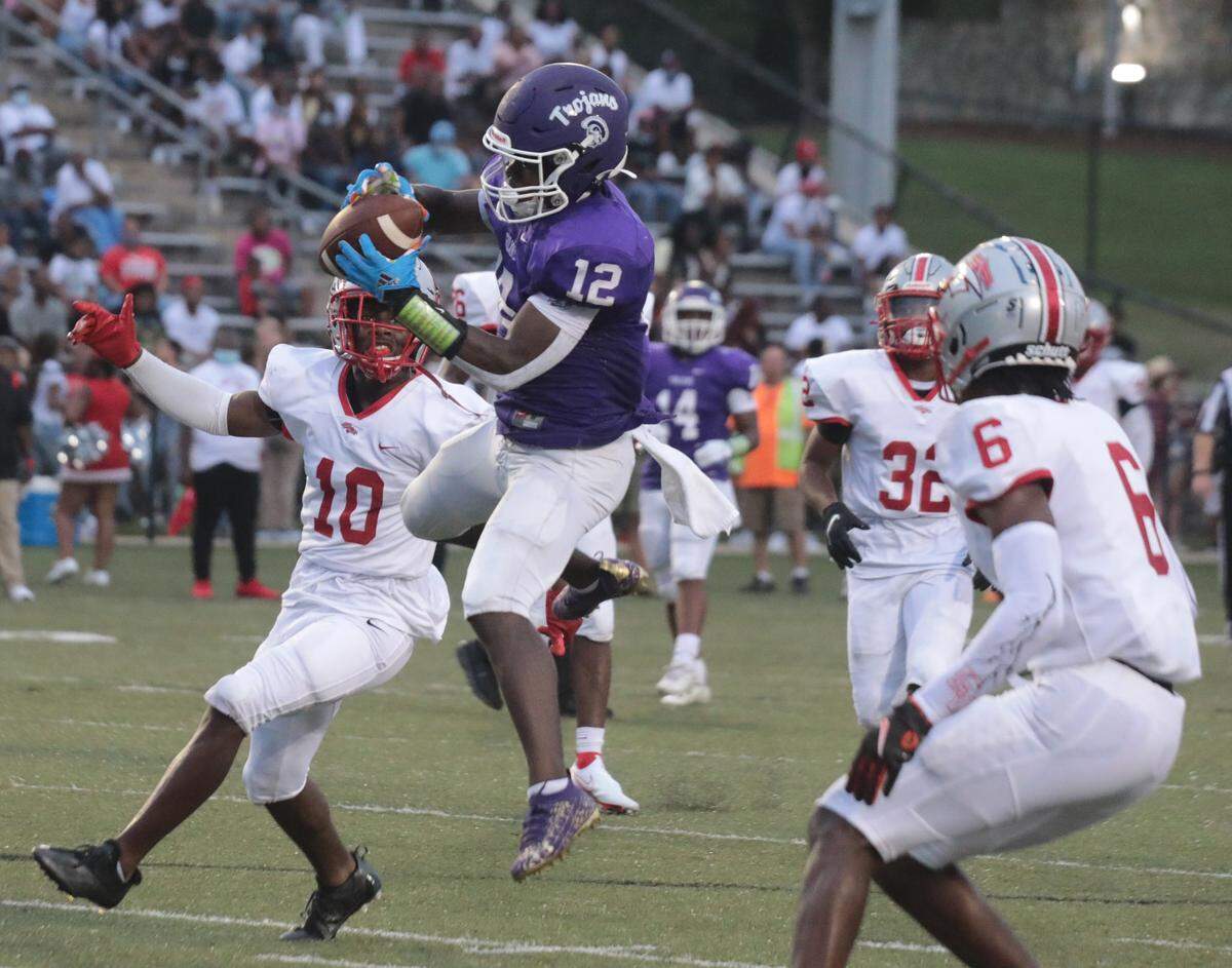 Northwestern’s Calique Cunningham jumps to catch the ball Saturday as the Stallions and Trojans compete at District Three Stadium.