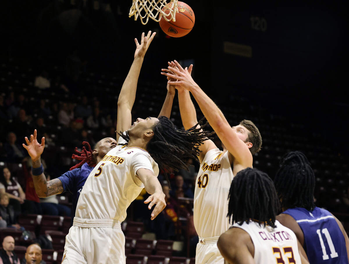 Winthrop’s Yoro Diallo (5) and Alex Timmerman (40) try to keep the ball from a defensive player Friday at the Winthrop Coliseum.