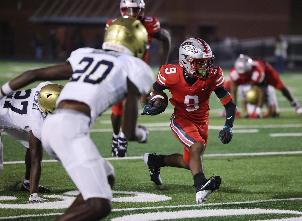 South Pointe’s Dailan Duncan runs with the ball against Spartanburg’s Elijah Roseburgh (20) and C.J. Woodruff Friday in Rock Hill.