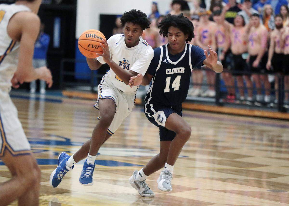 Fort Mill’s Darryl Carrington heads to the basket alongside Clover’s Jaylon Hoover.