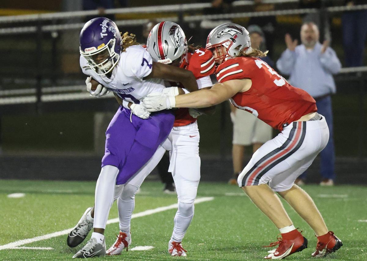 Northwestern’s Tadarrian Knox (7) is brought down by South Pointe’s Jaden Barnette, middle, and Brysen Ginn.