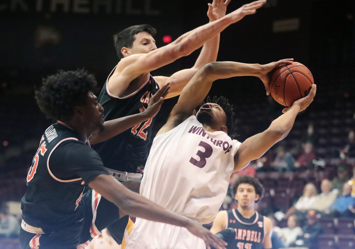 Winthrop’s Michael Anumba shoots around Campbell’s Jesus Carralero (12) and Cedric Henderson, Jr. (45).