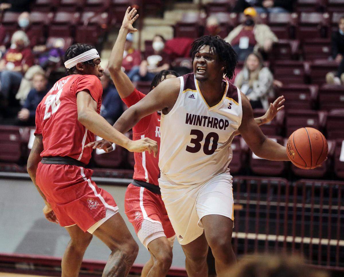 Winthrop’s D.J. Burns Jr. looks for an opening around Radford’s Dravon Mangum.