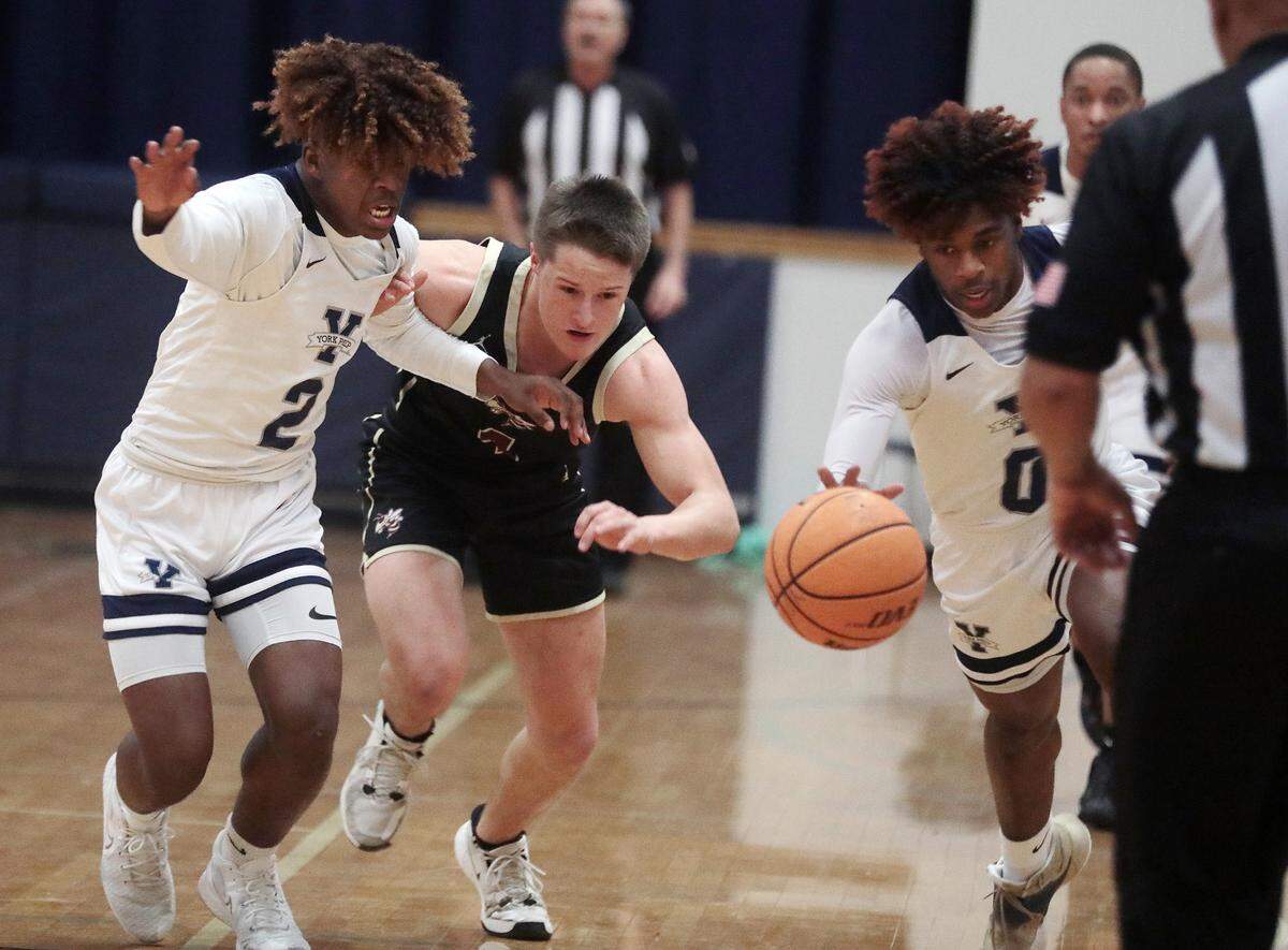 York Preparatory Academy twins Kory Davis, left, and Kendall Davis, right, try to keep the ball away from Buford High School’s Brody Sanders on Friday, Feb. 11, 2022 in Rock Hill.